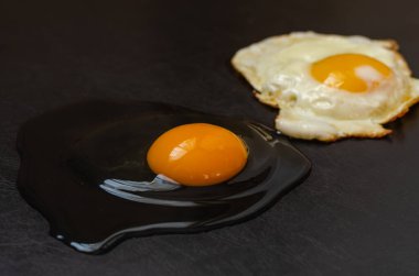 Koyu bir arka planda çiğ ve kızarmış yumurta.. 