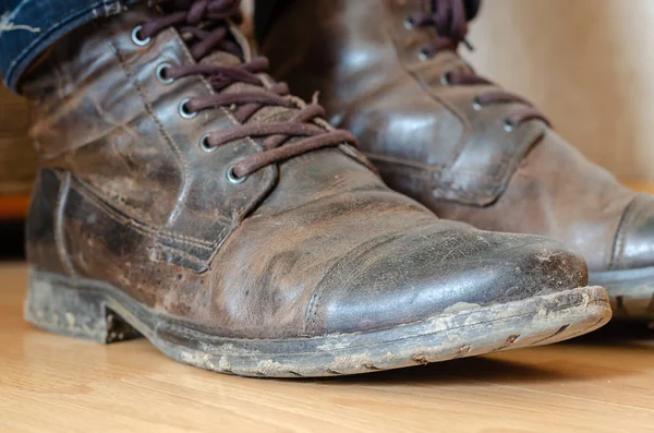 木製の床に汚れた革のブーツの男の足. — ストック写真