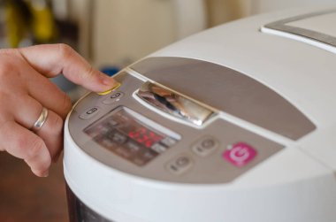 Bir kadın eli, elektrikli çoklayıcının düğmelerine basar..