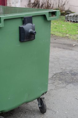 Dışarıdaki yeşil plastik çöp kutusu..