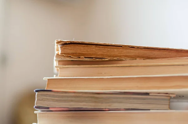 Uma pilha de livros antigos numa secretária numa biblioteca . — Fotografia de Stock