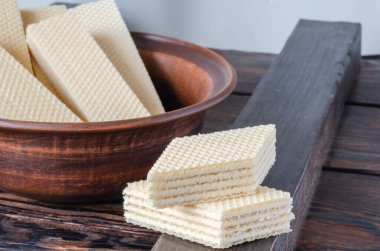 Ahşap arka planda şekerleme waffle 'ları. İki elmas şekilli şekerleme, teke tek. Perakende satış ve toptan şekerleme ticareti. Yakın plan. Seçici odak.