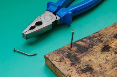 Kerpeten, çivi ve eski bir tahta. Penseyle çivi söküyorum. Tüm ticaretlerden ya da DIY 'den Jack. Yakın plan. Seçici odak.