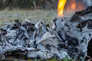 Belgeleri yakın plan yakma. Özellikle de açık havada çıkan yangın belgeleriyle yok edildi. Kanıt yok etme ya da yazışma kavramı. Yan görüş. Seçici odak.