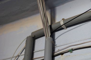 Duvardaki internete bağlanmak için kablolar. Bir Lan kablo grubu plastik boruların içine yönlendiriliyor. Binanın içinde iletişim var. Seçici odak.