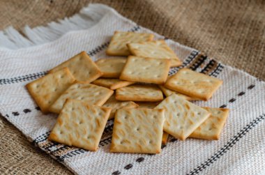 Keten havluya tuzlu kraker. Yemek pişirdikten sonra ev yapımı ikramlar serin oluyor. Geleneksel ikramlar. Göz hizasında atış. Seçici odak.