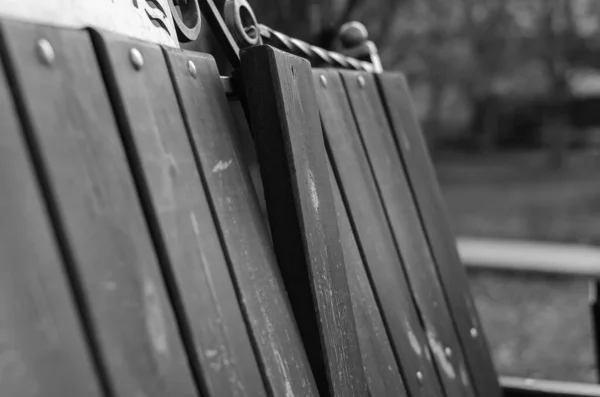 壊れた木製の通りのベンチ 壊れた背中と公園のベンチ サイドビュー 目のレベルの撮影 選択的フォーカス 白黒写真 — ストック写真