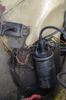 Eski bir arabanın ateşleme bobini. Motor bölümündeki ateşleme bobininin görüntüsü. Çalışan gerçek bir araba. Seçici odaklanma. İnsanlar olmadan.