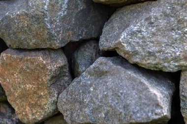 Görgüsüz granit kaldırımlar. Granit taşlar teke tek istiflenmiş. Büyük çiğ granit parçaları. Soyut arkaplan. Seçici odaklanma. Yakın plan..