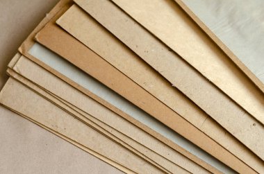 Kalın kahverengi karton çarşaflar. Bir yığın dikdörtgen geri dönüşümlü kağıt. Soyut arkaplan. Yukarıdan bak. Seçici odaklanma. Yakın plan..