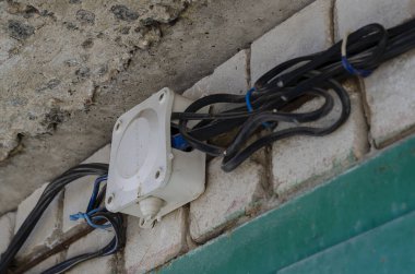 Elektrik tesisatı ve kablolar için bağlantı kutusu. Bir evin tuğla duvarındaki alüminyum kablolar. Tepeden tırnağa. Seçici odak.
