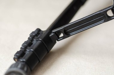 Siyah tripodun bacağı yakın plan. Siyah plastik çıtçıtlı metal ayak. Fotoğraf ekipmanları. Yan görüş. Seçici odak.