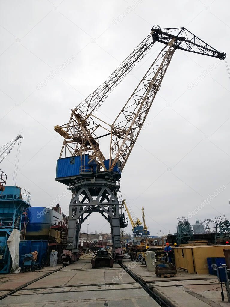 Powerful heavy duty crane in stock. Multifunctional gantry crane loading process. Port cargo warehouse outdoors. Selective focus.