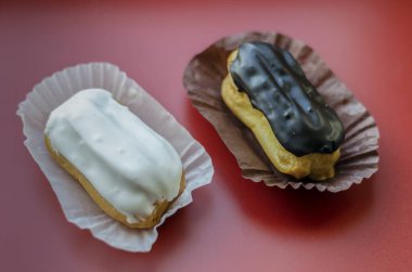 Kremalı kremalı muhallebi kekleri. Üzerine kahverengi ve beyaz şekerli kremalı iki muhallebi keki döküldü. Çay ya da kahve için tatlı ikramları. Yakın plan. Seçici odak.