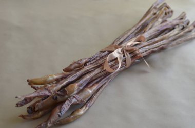 Köpekler için boğa sopaları. Ekstra uzun kurutulmuş sığır eti buketi. Sağlıklı kurutulmuş hayvan maması. Çuval bezi üzerinde bir grup ödül. Seçici odak.