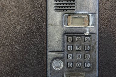Bir apartmanın kapısındaki Dirty Intercom. Ön kapıdaki dahili telefonun sağlıksız durumu. Sağlıksız koşullar. Göz hizasında atış. Yakın plan..