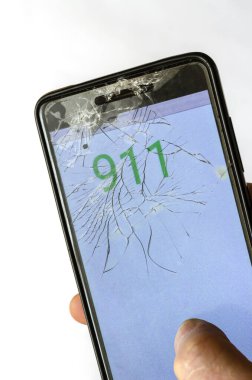 Elinde kırık bir telefon. Acil yardım numarası 911 olan bir cep telefonu. Acil ve acil durum. Akıllı telefondan 911 'i arıyorum. Bir açıdan üstten bak. Seçici odak.