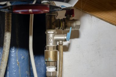 Elektrikli su ısıtıcısı için emniyet vanası. Sıcak su sisteminin tozlu boruları. Tesisat işi. Yan görüş. Seçici odaklanma. Yakın plan.