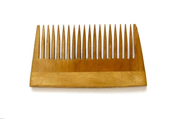 Wooden hair comb on white background. Natural brown wooden comb for hair. Combined wood. View from above.