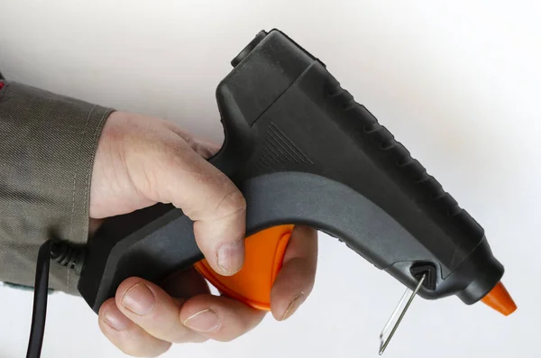 Mão Segura Uma Pistola Cola Eléctrica Homem Roupa Cinzenta Protectora — Fotografia de Stock