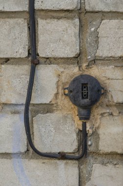 Duvardaki eski elektrik düğmesi. Tuğla bir duvarda eskimiş düğme. Üretimde mesleki güvenlik. Sigorta ve güvenlik. Yakın plan. Seçici odak.