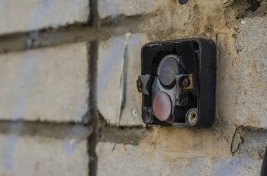 Duvardaki eski elektrik düğmesi. Yıpranmış paket anahtarı. Üretimde mesleki güvenlik. Sigorta ve güvenlik. Yan görüş. Yakın plan. Seçici odak.