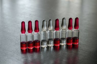 B grubunun vitamin ampulleri. Siyah bir masaya enjekte etmek için dokuz doz B12, B1 ve B6 vitamini. Yakın plan. Seçici odak.