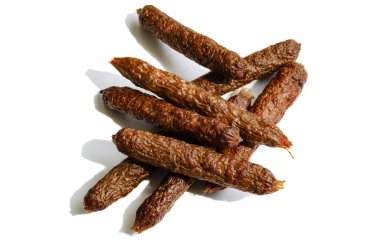 Köpekler için kurutulmuş sosis. Köpekleri tedavi etmek için bir grup kurutulmuş biftek sosisi. Doğal kurutulmuş ikramlar. Terfi ve şımartma. Beyaz arka planda izole edin. Hayvan malzemeleri. Seçici odaklanma. Yakın plan..