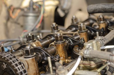 Bir arabanın motor bölmesi, yakın plan. Kapakçık kapağı olmadan karbüratör motorunun detaylı görüntüsü. Yan görüş. Seçici odak.