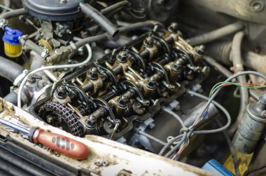 Yolcu vagonunun motor bölmesi. Kapakçık kapağı olmadan karbüratör motorunun detaylı görüntüsü. Vanalar, rocker kollar, iticiler ve yaylar. Benzin motorunun gaz dağıtımı. Bir açıdan üstten bak. Seçici odak.