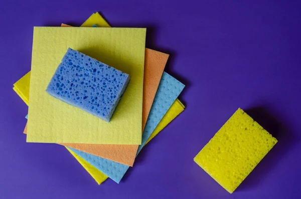 キッチンナプキンと青の背景にスポンジ 4つの多色のクリーニングナプキンと2つのキッチンスポンジ 自家製ルーチン 接近中だ 選択的焦点 — ストック写真