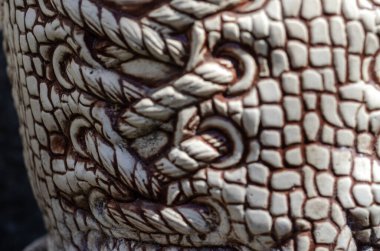 Açık havada seramik bir heykel parçası. Seramik ayakkabı bağcığı. Seramik arka planda dantelli desen. Modern sanat. Yakın plan. Seçici odak.