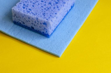 Mavi mutfak süngeri ve sarı peçete. Bulaşık ve temizlik için aksesuarlar. Ticari temizlik şirketi. Seçici odaklanma. Yakın plan..