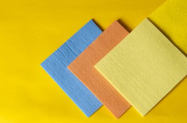 Sarıyı temizlemek için mutfak peçetesi. Dört peçete, sakin renk tonları. Kare mendillerin en üst görüntüsü. Seçici odak.