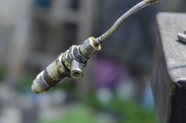 Dizel yakıt enjektöründe bir damla yakıt var. Metal tüpte tek yakıt enjektörü. Kürsüde yüksek basınçlı yakıt enjektörlerini kontrol ediyorum. Onarım ve onarım. Yan görüş. Seçici odaklanma. Yakın plan..