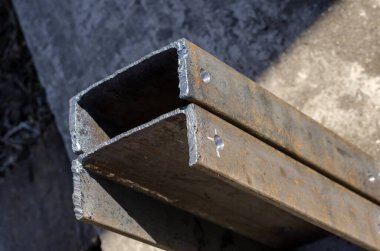 Metal inşaat detayları. Üst kısmında delikler olan iki metal kanal. Endüstriyel konular. Seçici odak.