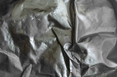 Düz olmayan bir yüzeyde gümüş boya. Gümüş boyayla boyanmış koruyucu kumaş. Soyut çoklu görev arkaplanı. Seçici odaklanma. Tek Renkli