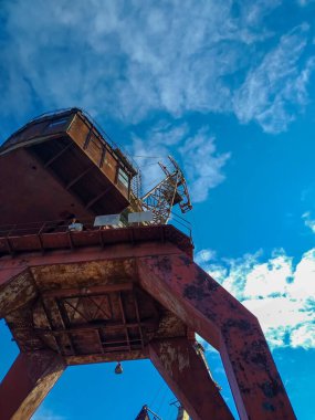 Gökyüzüne karşı eski bir vinç. Terk edilmiş bir fabrikanın bölgesindeki yüksek paslı vinç. Gerçek tersane. İflas ve yıkım. İnsanlar olmadan.