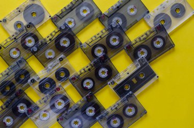 Sarı arka planda klasik ses kasetleri. Ses kasetlerinde 80 'lerin müziği. Eski şarkıların olduğu bir sürü ses kaydı. Boşluğu kopyala