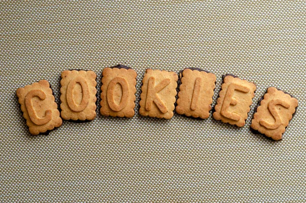 Cookies的单词用Cookie字母拼写出来 七块饼干 字母表分层成一个字 教育孩子的甜食 复制空间 后续行动 — 图库照片