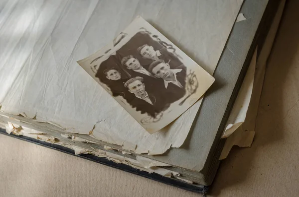 Black white archive photo of five young guys. Portrait of five friends. The photograph was taken in a photo studio around the 1940s. Real family photo album with worn pages. Family archive.