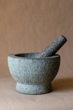 Kabuklu gri taş havan topu. Arka planda bej rengi granit havan topu var. Uzayı kopyala Seçici odak.