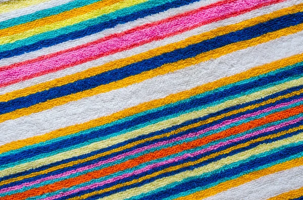 マルチカラーのストライプビーチタオルをクローズアップ 虹色のカラフルなタオル 肯定的な色 抽象的な背景 上からの眺め — ストック写真