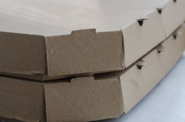 Yakın plan pizza için karton kutular. Bir yığın içinde iki kapalı kahverengi kutu. Yiyecek ambalajı ve teslimat. Kurye servisi. Yakın plan. Seçici odak.