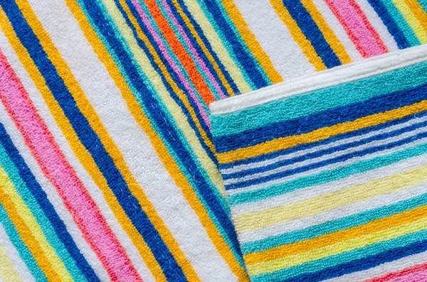 Multi-colored striped beach towel close-up. Colorful towel in rainbow colors. Positive colors. Abstract background. View from above.