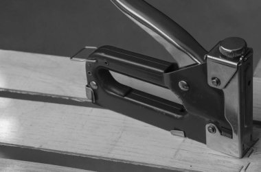 Endüstriyel zımba tahta bir kutunun üzerinde duruyor. Sebze ve meyve ambalajı, depolama ve taşımacılığı için çevre dostu ahşap kaplar üretimi. Endüstriyel konular. Marangoz işi. Tek Renkli