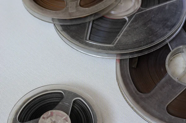 Old bobbins with audio recordings on a light background. Several plastic bobbins close-up. Back to the 60s. Selective focus.