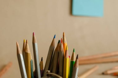 Çok renkli kalemleri olan bir kalem tutucu. Yakın plan. Çeşitli kullanılmış tahta kalemler. Ön plana odaklan. Göz hizasında atış. Seçici odak.