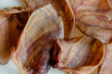 Evcil hayvan geçmişi için doğal çiğneme ikramı. Kurutulmuş domuz kulağı. Evcil hayvan dükkanı, hayvan malzemeleri. Yukarıdan görüntüle.