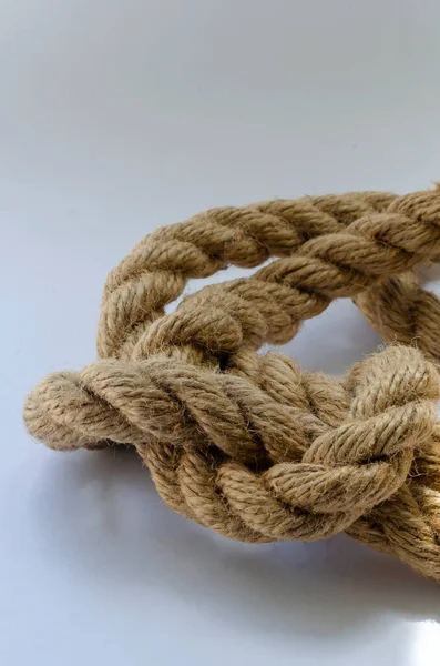 白い背景に麻ロープのクローズアップの結び目 結び目の詳細なスナップショット 海の主題と冒険 選択的焦点 — ストック写真